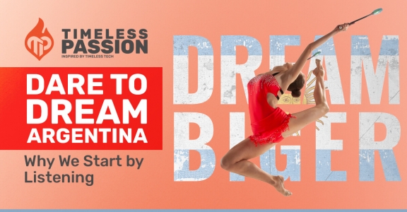 Gymnast performing a dynamic leap in front of the Dare to Dream Argentina banner, representing the Timeless Passion sports initiative supporting athletes’ dreams.